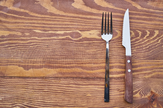 Foto forcella e coltello sulla tavola di legno