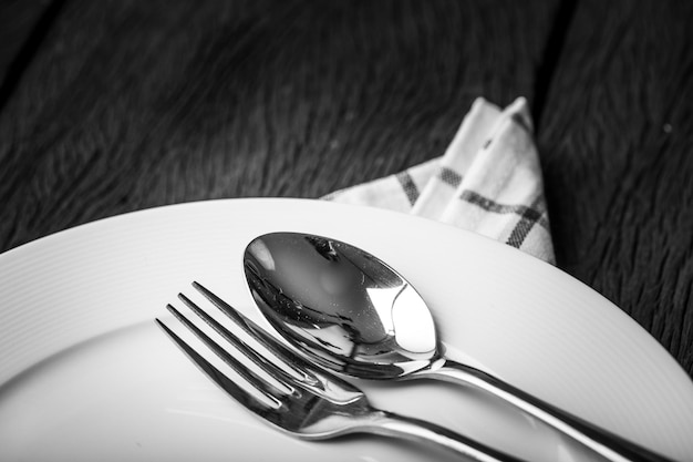 fork and spoon in white plate for dinner.