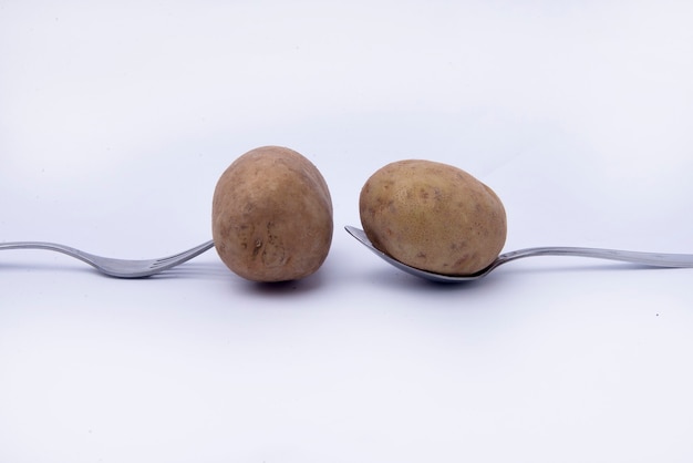 Fork and spoon with potato isolated over white background