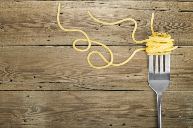 Fork with just spaghetti around it on wooden table