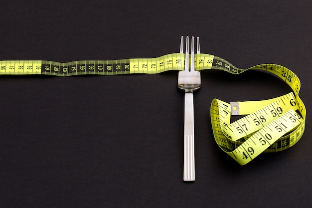 Fork with a measuring tape, diet or healthy eating concept