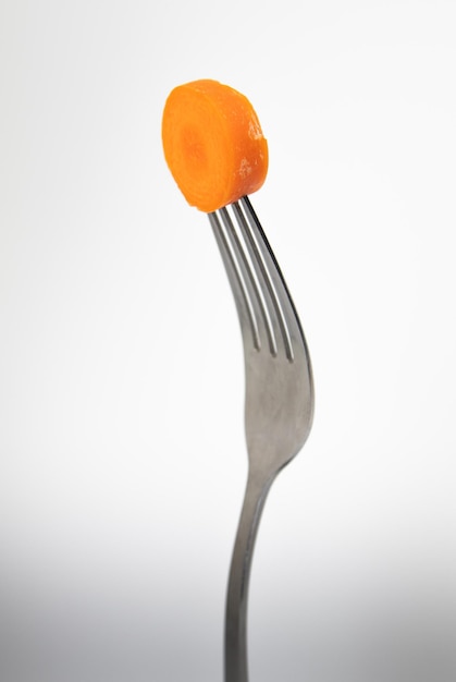 A fork with a piece of carrot on it