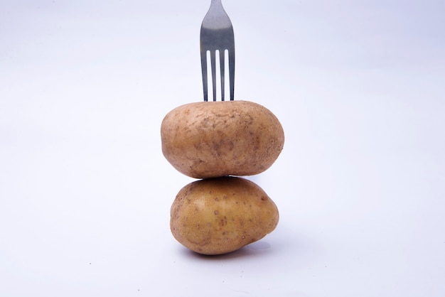 Fork with a stack of potatoes isolated over white background