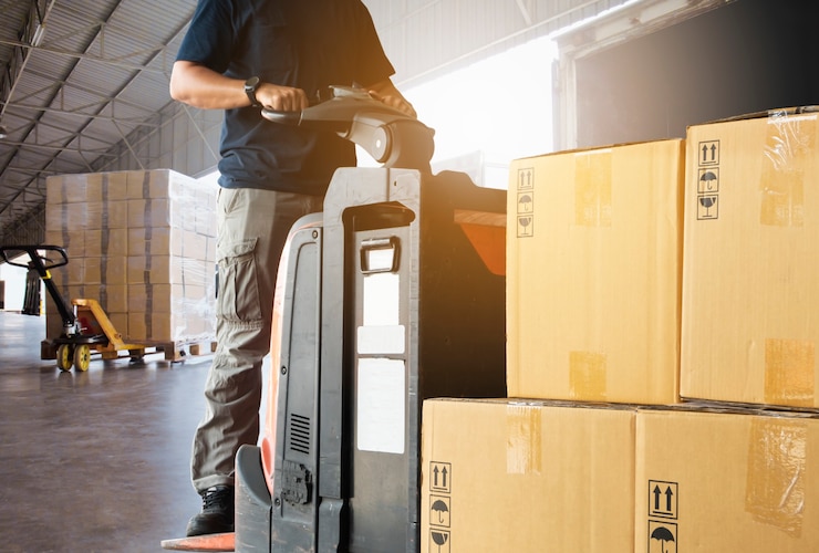 Photo forklift driver loading pallet shipment goods into a truck