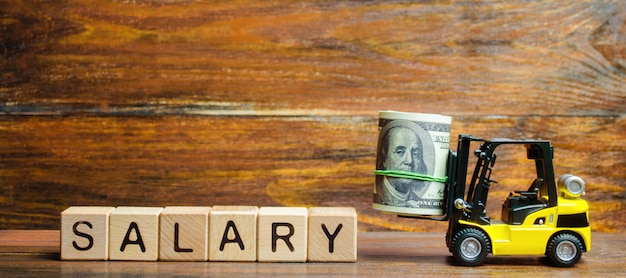 Photo forklift truck carries a bundle of dollars to the inscription salary