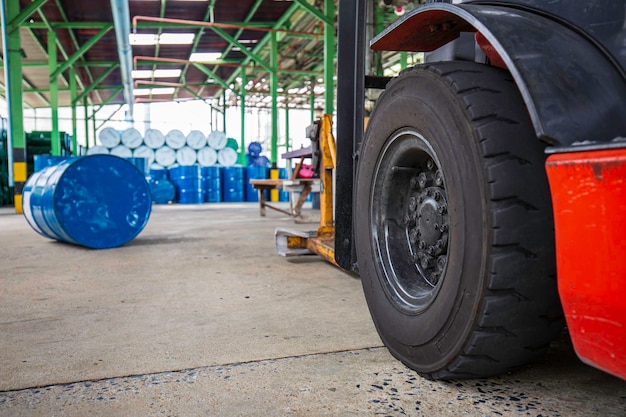 La ruota del carrello elevatore solleva fusti chimici barili di petrolio tamburi chimici blu orizzontali