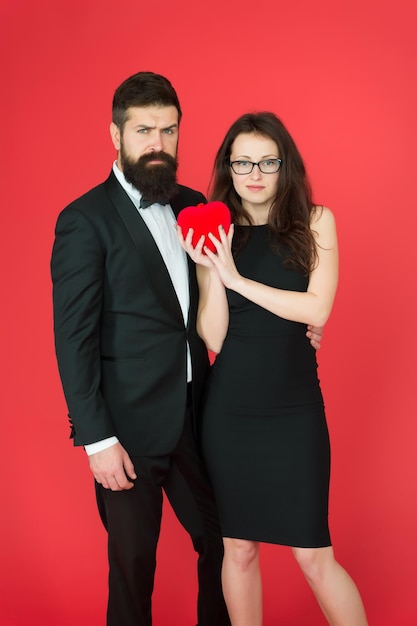 Formal couple with red valentine heart take my heart one heart for two sexy woman and mature man with beard couple in love formal couple Love relationship expert in love formal fashion expert