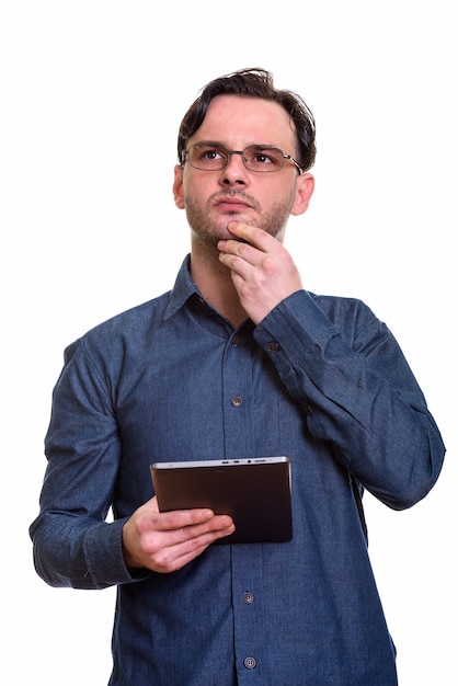 formal young man holding digital tablet while thinking