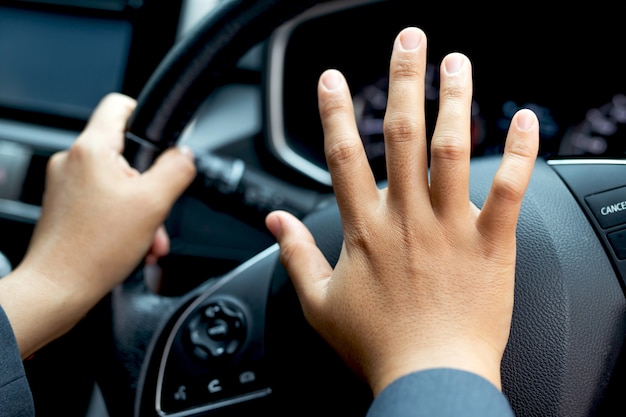 Formally dressed woman honking her horn while driving