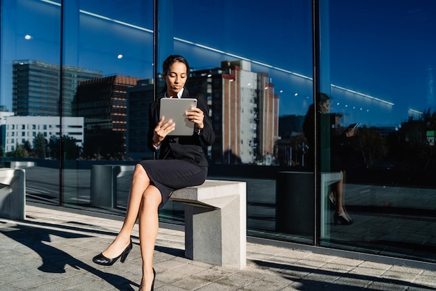 Formele zakenvrouw met tablet op straat