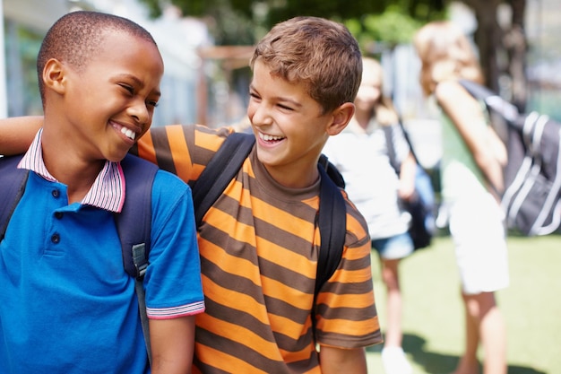 学校で永続的な友情を築く学校の遊び場で一緒に大笑いする2人の男の子コピースペース