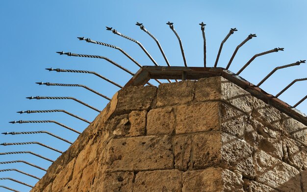 Fortress wall with iron peaks against the sky in Akko