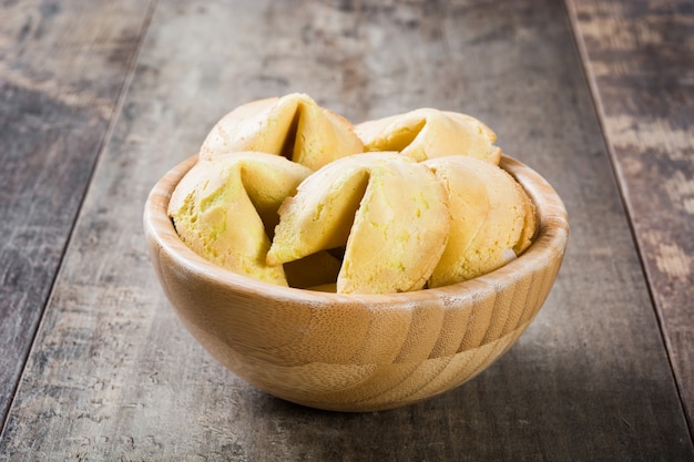 Fortune cookies in bowl on wooden table