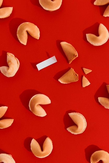 Fortune cookies on red background with deep long shadows blank paper for prediction words