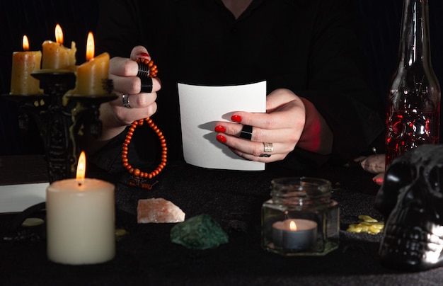 The fortune teller is holding a photo and a rosary