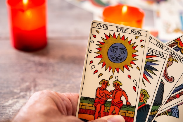 Fortune teller reading a future by tarot cards on rustic table