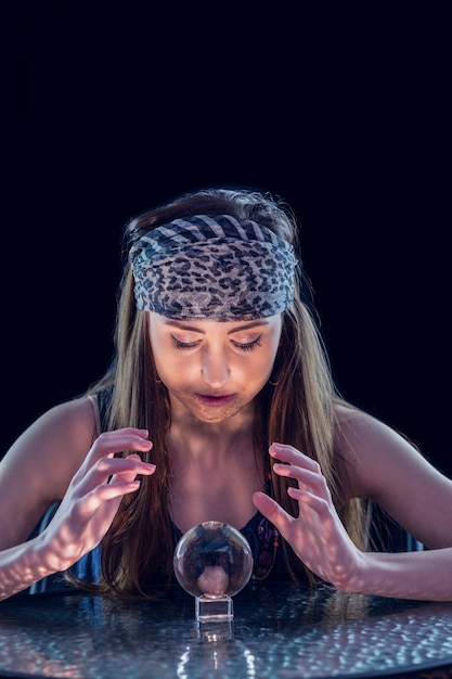 Fortune teller using crystal ball on black background