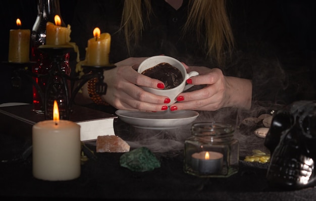 Foto indovinare sulla terra del caffè un indovino consegna una tazza di candele al caffè