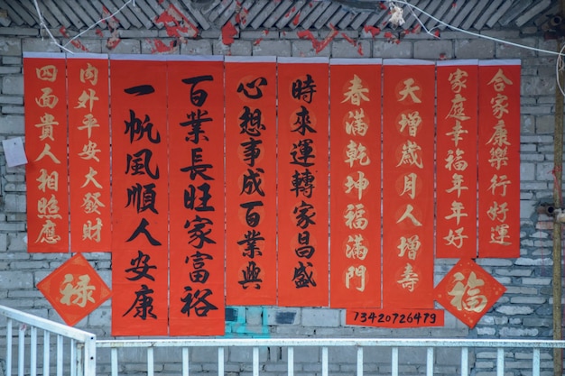 중국 광둥성 포산시. 2021년 2월 8일. 봄 축제를 위한 인사와 함께 연을 쓰는 사람들. 포산 Kuaizi 거리에서 중국 새해 축하 준비