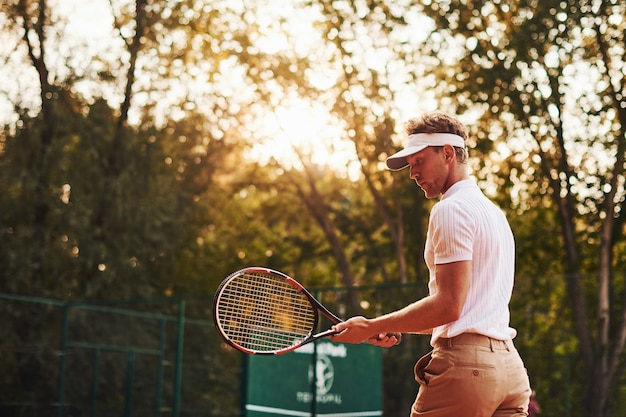 Foto in beweging. Jonge tennisser in sportieve kleding is buiten op het veld.