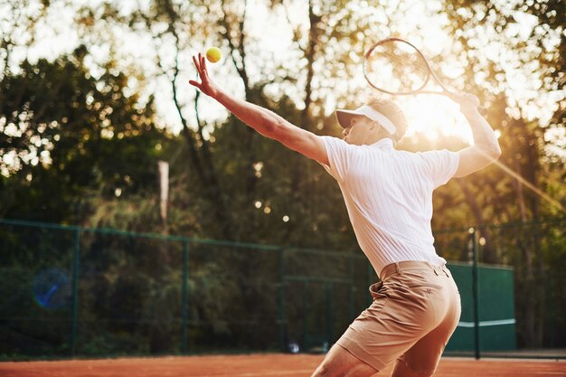 Foto in beweging. Jonge tennisser in sportieve kleding is buiten op het veld.