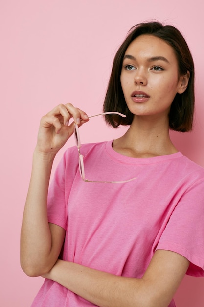 Foto mooi meisje in een roze tshirt mode zonnebril geïsoleerde achtergrond