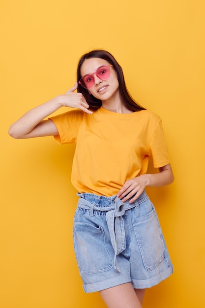 Foto mooi meisje mode in gele tshirt denim shorts geïsoleerde achtergrond