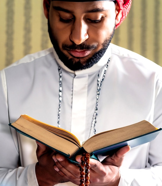 Foto moslim man leest uit de koran en houdt gebedskralen vast