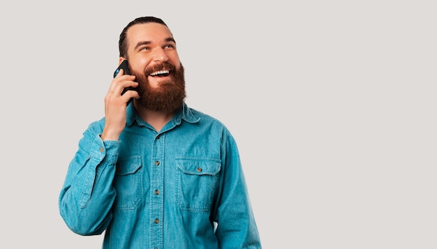 Foto op bannerformaat van een man die telefonisch praat terwijl hij naar de kopieerruimte kijkt