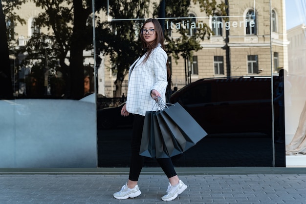 Foto op volledige grootte van een jonge vrouw die gaat winkelen voor koopjes. Gelukkig mooi meisje met aankopen. Zwarte vrijdag