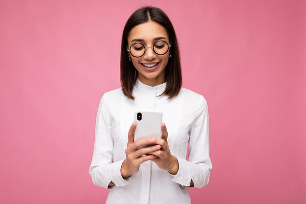 Foto-opname van een aantrekkelijke, goed uitziende jonge vrouw die een casual stijlvolle outfit draagt