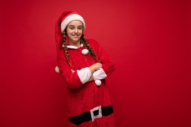 Foto-opname van een vrij gelukkig positief lachend brunette meisje met staartjes die kerstmankleding dragen