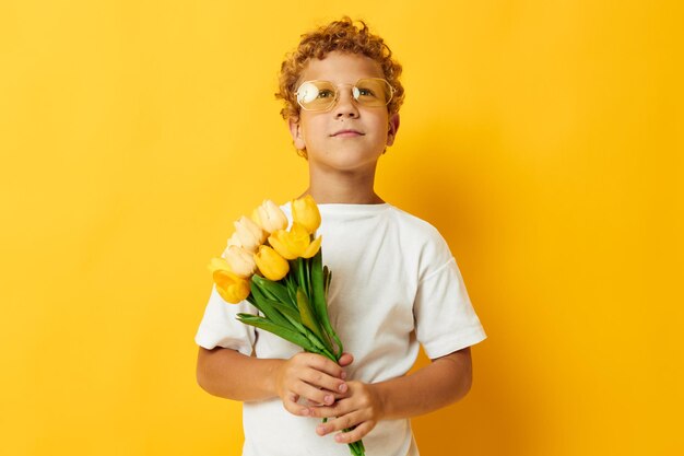 Foto portret krullend jongetje met gele bloemen poseren jeugd plezier geïsoleerde achtergrond ongewijzigd