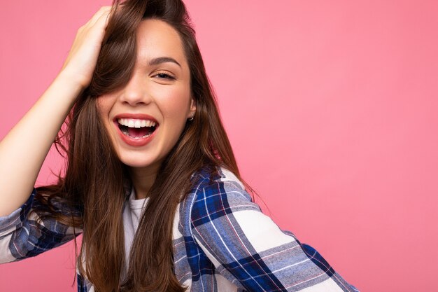 Foto portret van jonge mooie glimlachende hipster brunette vrouw in trendy blauw en wit overhemd