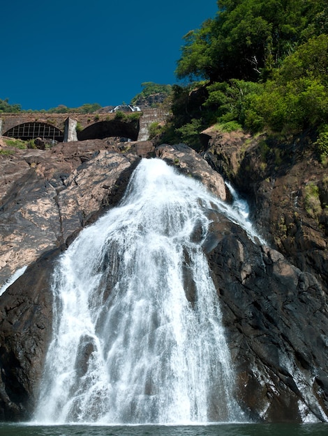 Foto prachtige hoge waterval op de goa vlakbij waar passerende treinen