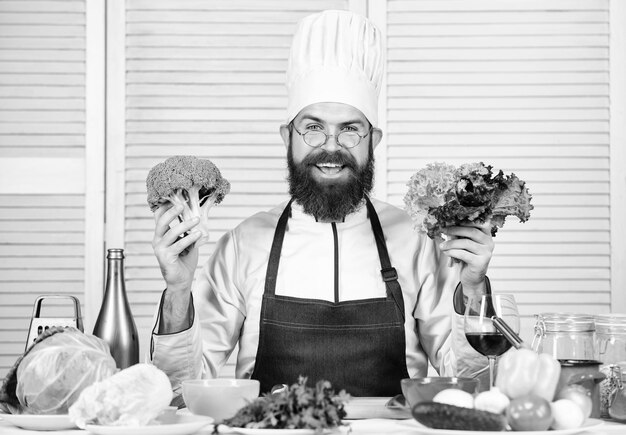 Foto's van eten Vegetarisch Rijpe chef-kok met baard Bebaarde man kok in de keuken culinaire Chef-kok met hoed Geheime smaakrecept Dieet en biologisch voedsel vitamine Gezonde voeding koken