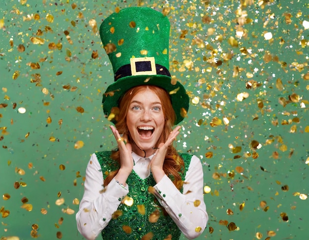 Foto schreeuwende vrouw met leprechaun hoed onder een douche van confetti