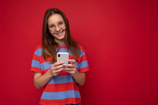 Foto shot van aantrekkelijke positieve knappe jonge vrouw, gekleed in casual stijlvolle outfit in evenwicht