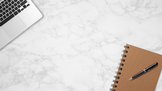 Foto superior de escritorio de trabajo con libreta y laptop