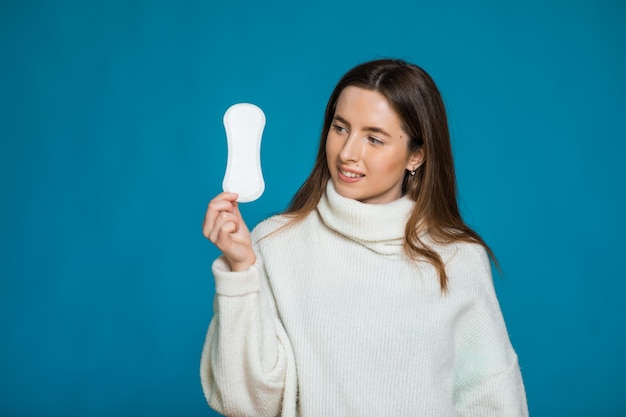 Foto van aantrekkelijke jonge dame houdt schoon maandverband tevreden met de kwaliteit ervan