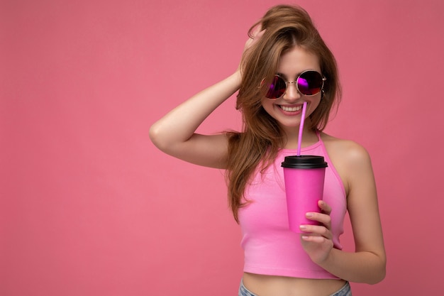 Foto van aantrekkelijke jonge gelukkig lachende vrouw die alledaagse stijlvolle kleding draagt, geïsoleerd over