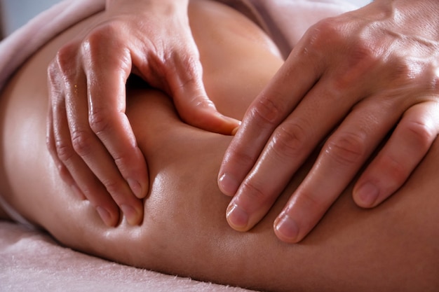 Foto foto van anti-cellulitis massage. massage van de dijen en billen.