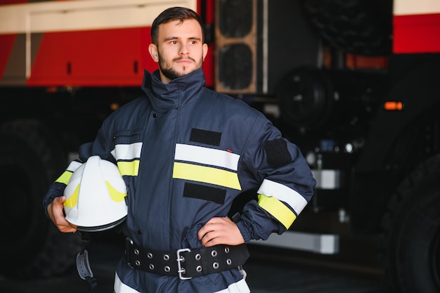 Foto van brandweerman met gasmasker en helm bij brandweerwagen