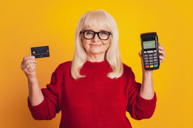 Foto van charmante bejaarde dame met creditcard draadloze terminal paypass