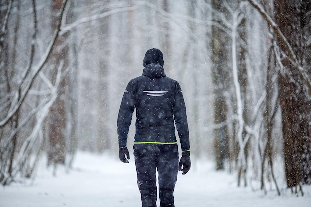 Foto van de achterkant van een man in sportkleding tijdens een run in de winter