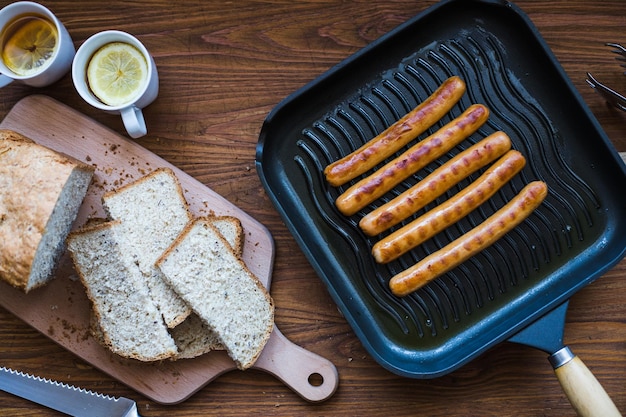 Foto van de tafel met gegrilde worstjes en brood bovenaanzicht