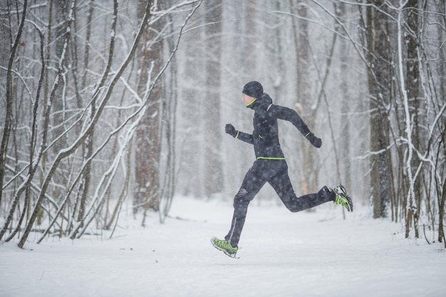 Foto van de zijkant van de man in sportkleding tijdens een run in de winter