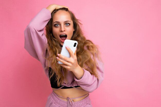 Foto van een aantrekkelijke gekke verbaasde verrast jonge vrouw, gekleed in casual stijlvolle kleding staan