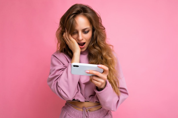 Foto van een aantrekkelijke gekke verbaasde verrast jonge vrouw, gekleed in casual stijlvolle kleding staan