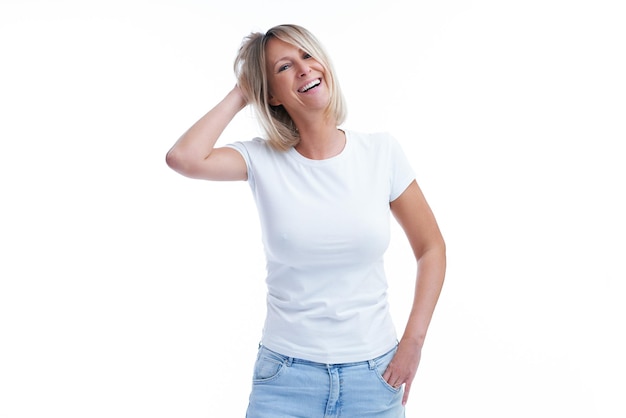Foto van een blonde vrouw over een geïsoleerde achtergrond die blije gezichten trekt
